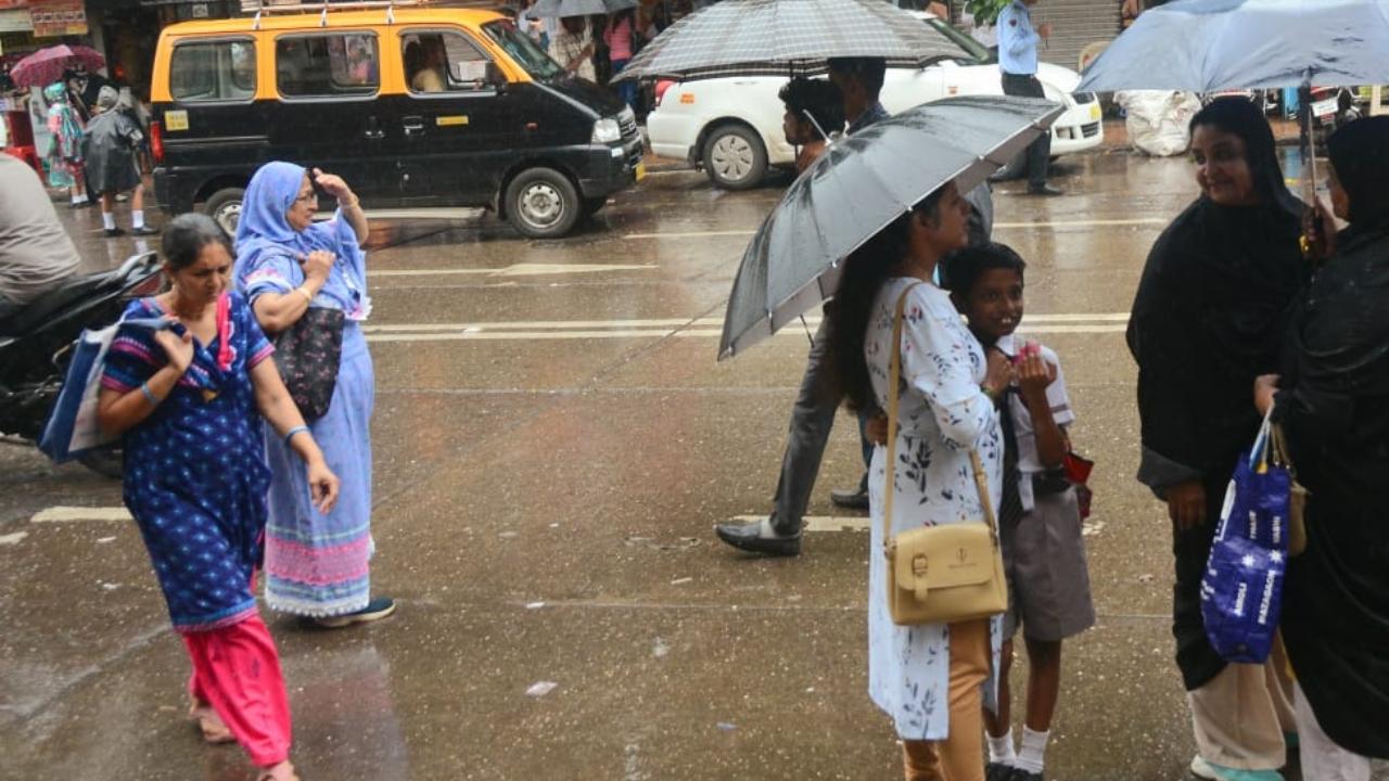 Parents wait near a school at Byculla amid heavy rain showers in the city. Pic/Sameer Abedi