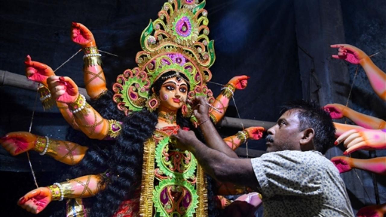 An artist gives finishing touches to an idol of Goddess Durga during ongoing Durga Puja festival, in Tezpur