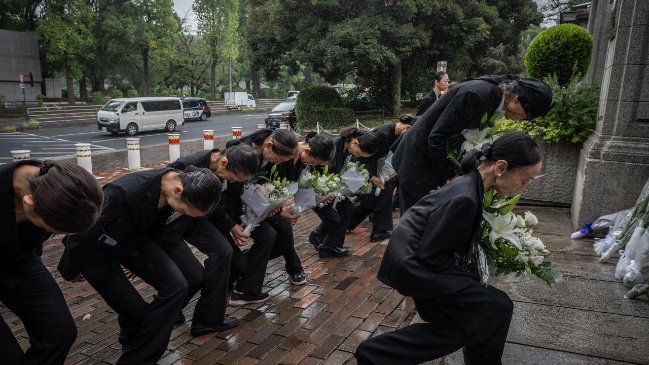 Members of a ballet company lay flowers outside the British embassy following the death of Queen Elizabeth II, in Tokyo