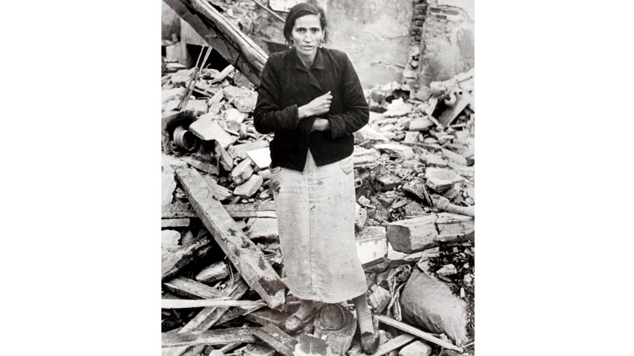 A woman amid rubble from buildings destroyed by Nationalist air raids in Spain, 1936