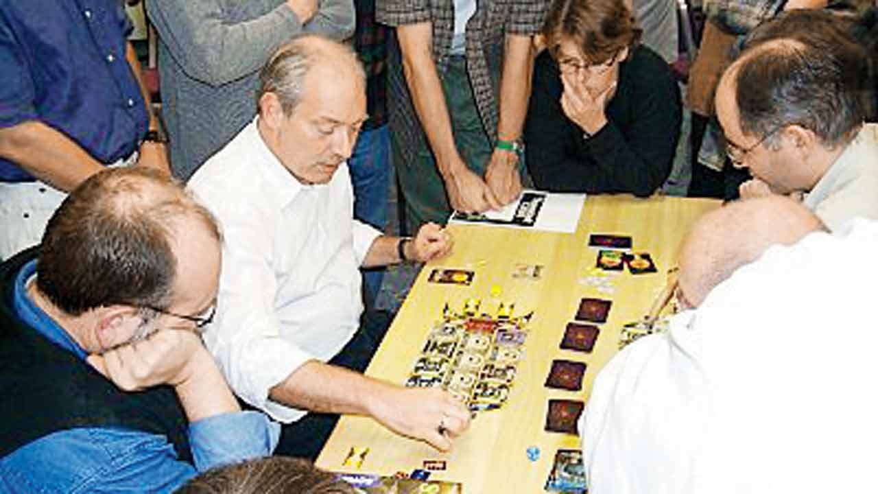 Klaus Teuber (centre) playing an early version of the game. Pic Courtesy/Wikimedia Commons