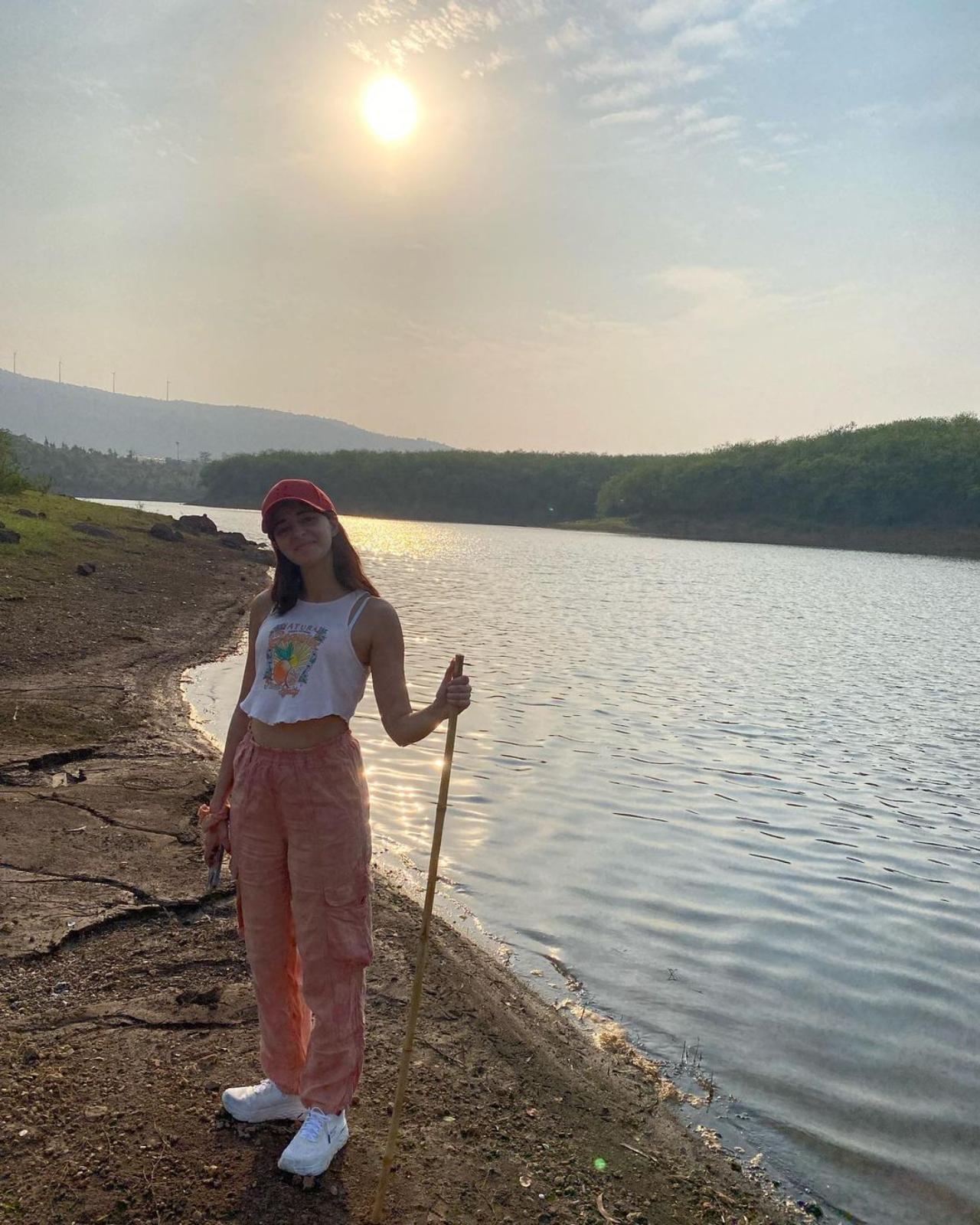 In the first picture, Ananya could be seen standing near a lake dressed in a casual outfit and holding a stick
