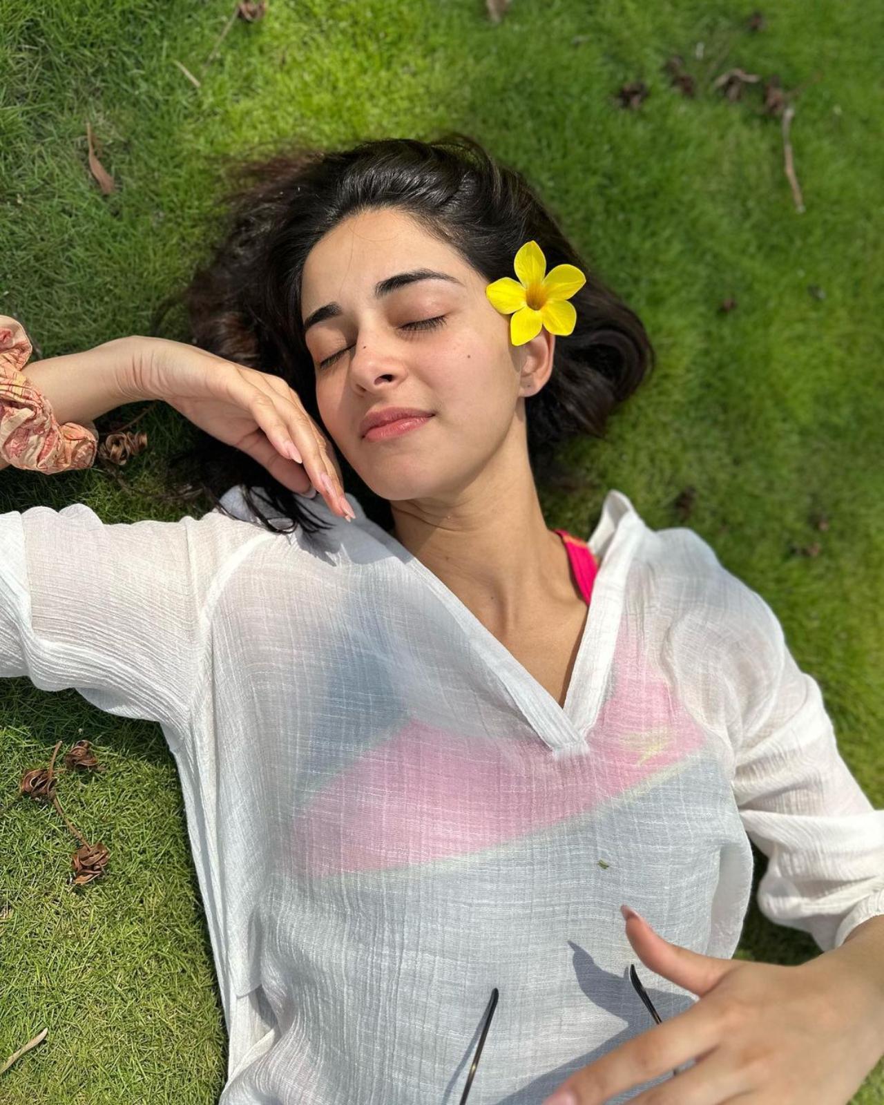 In another picture, she could be seen lying on the ground enjoying the atmosphere with her eyes closed. She looked beautiful in a no-makeup look. Don't miss to check out the yellow flower in her hair