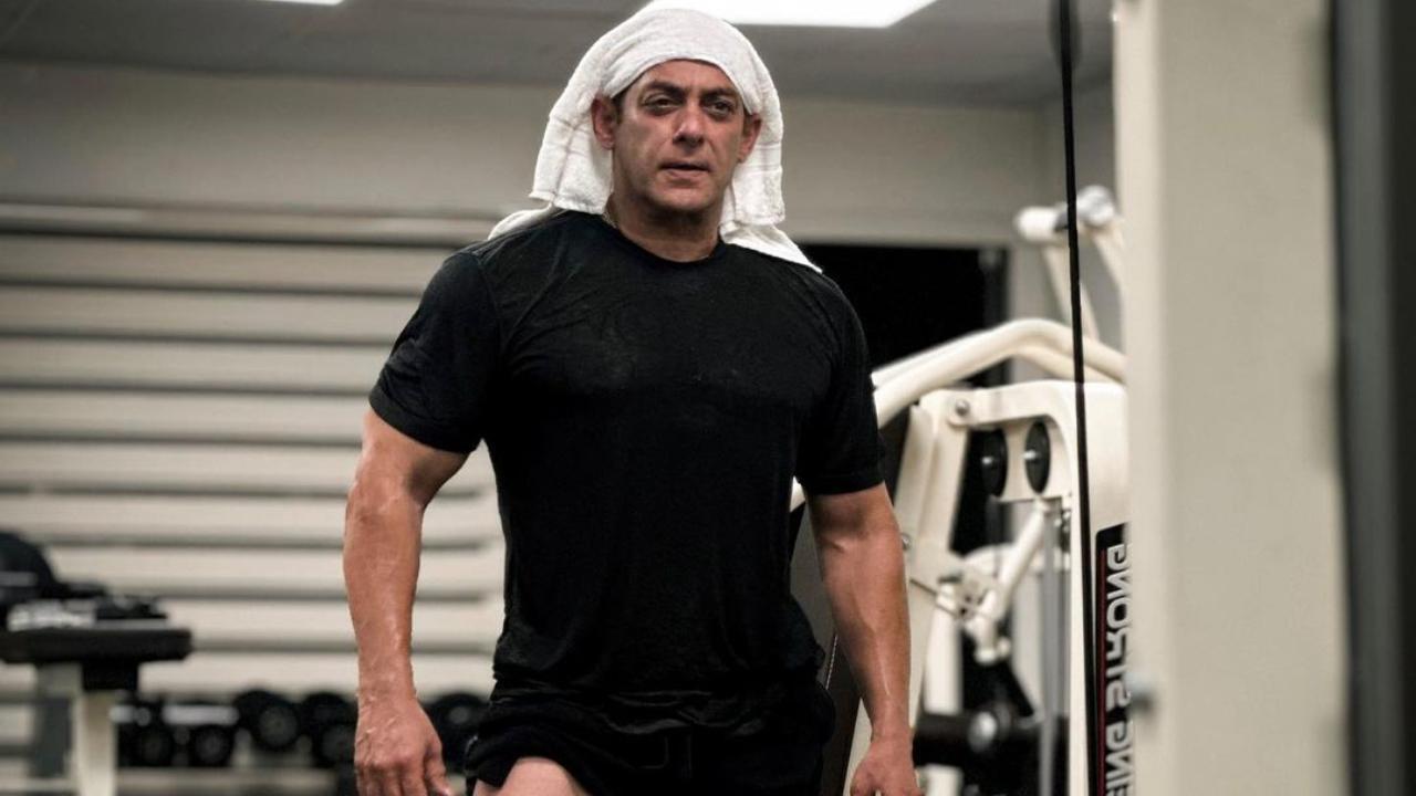 Just a day after treating his Instagram fans and followers with a shirtless photo, our beloved Bhaijaan has dropped yet another photo which is making netizens fall head over heels for the superstar. On Friday, Salman Khan took to his official Instagram handle and dropped a post-workout photo. In the photo, the actor can be seen dressed in an all-black gym ensemble. The photo shows Salman flaunting his sweaty and flawless body. The actor who is seen wearing a white hand towel on his head looks like an absolute thirst trap as he shows off his muscled-up legs in the new post. Read full story here