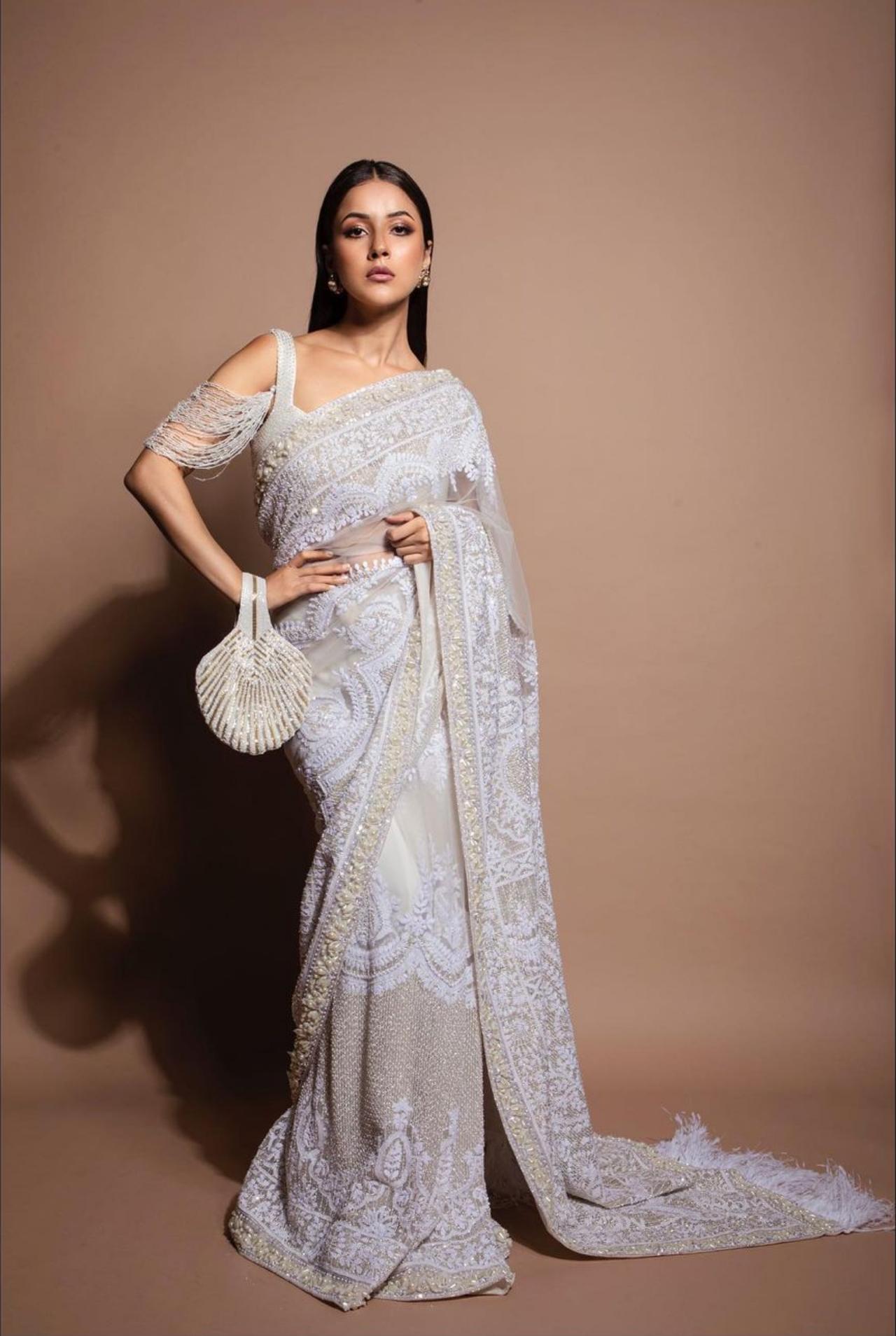 Serving us ethnic realness, Shehnaaz slipped into an elegant lavender saree, filled with intricate embroidery and a fringe pallu. To top off the look, Gill chose a flashy white and gold striped handbag.
