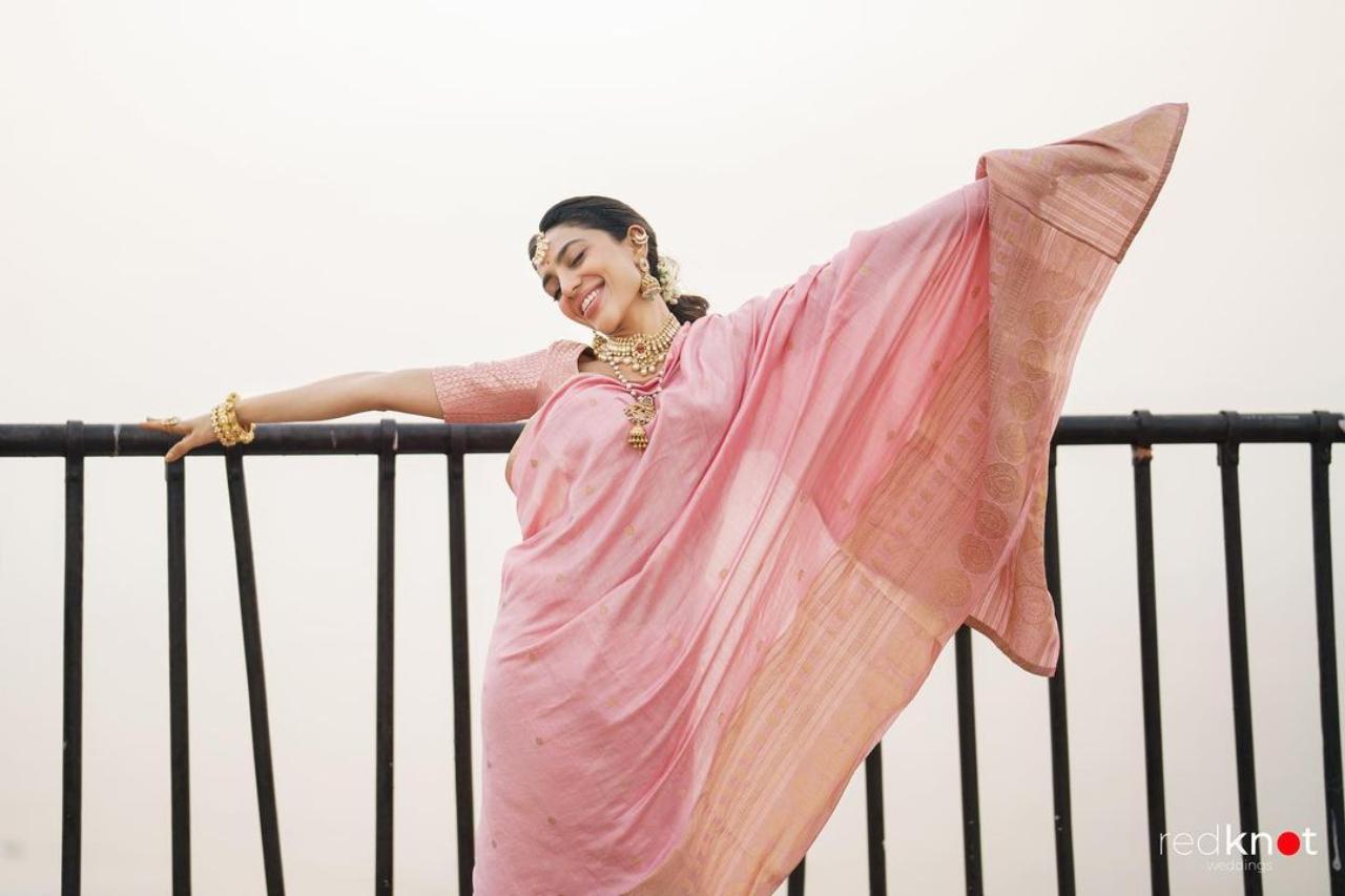 The actress looked stunning in a custom made pink saree paired with elegant gold jewellery which she wore to the wedding. The choice of jewellery beautifully complemented her look and it was safe to say all eyes were on her. With her delicate looks and graceful demeanour, she had a striking resemblance to a rose