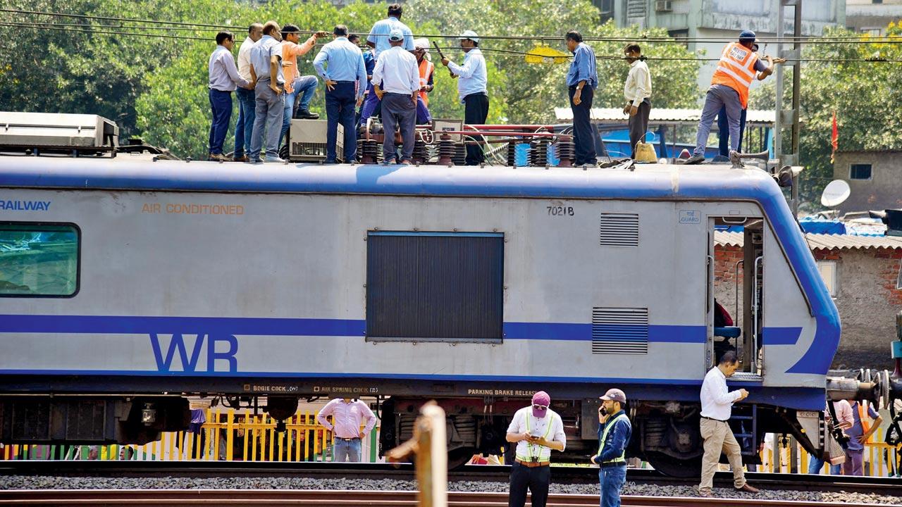 Commuters are brought out of the AC local even as Railway officials attempt to fix the snag on Wednesday morning