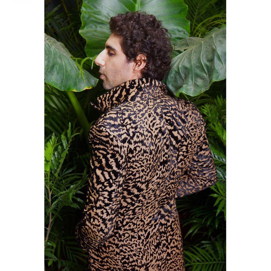 The unique pattern of the coat adds a touch of wild elegance to his ensemble, while his confident demeanor completes the striking look. 