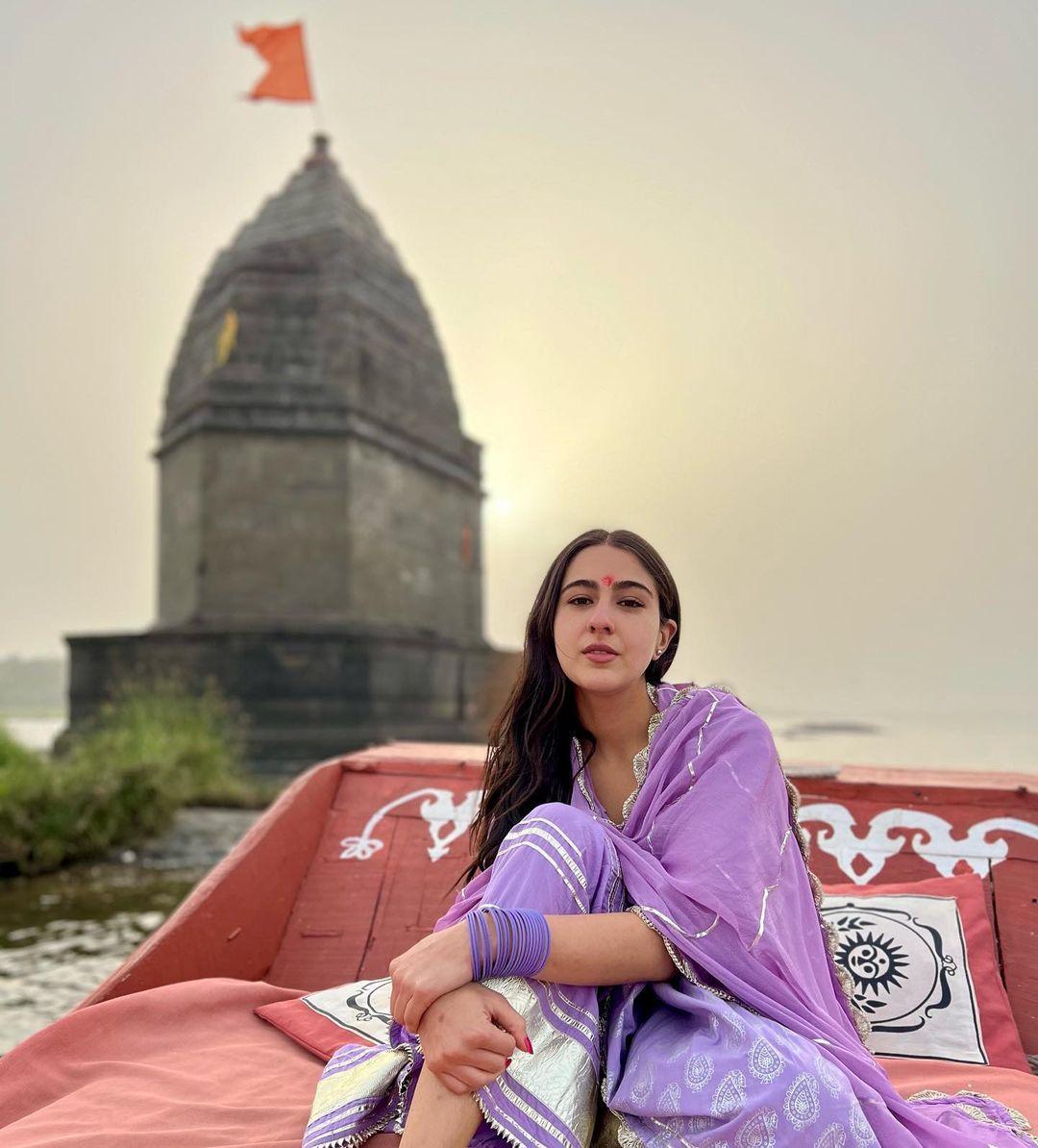 Sara Ali Khan adorns a resplendent purple salwar suit adorned with intricate white patterns.