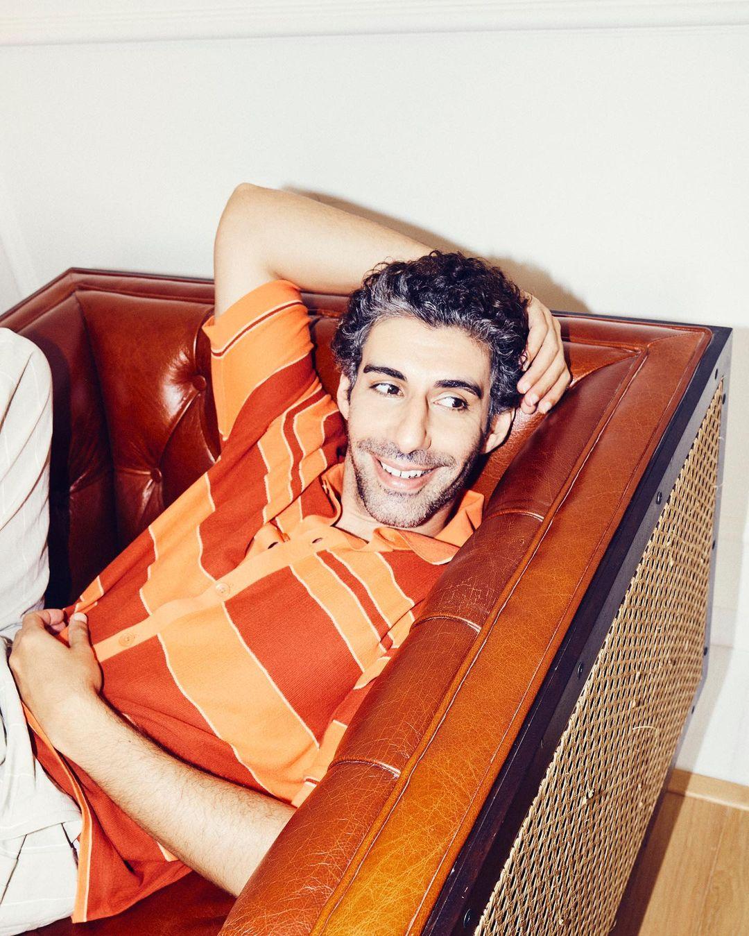 Dressed in a vibrant orange shirt, Jim Sarbh exudes a lively and energetic aura. The bold choice of color adds a pop of vibrancy to his ensemble