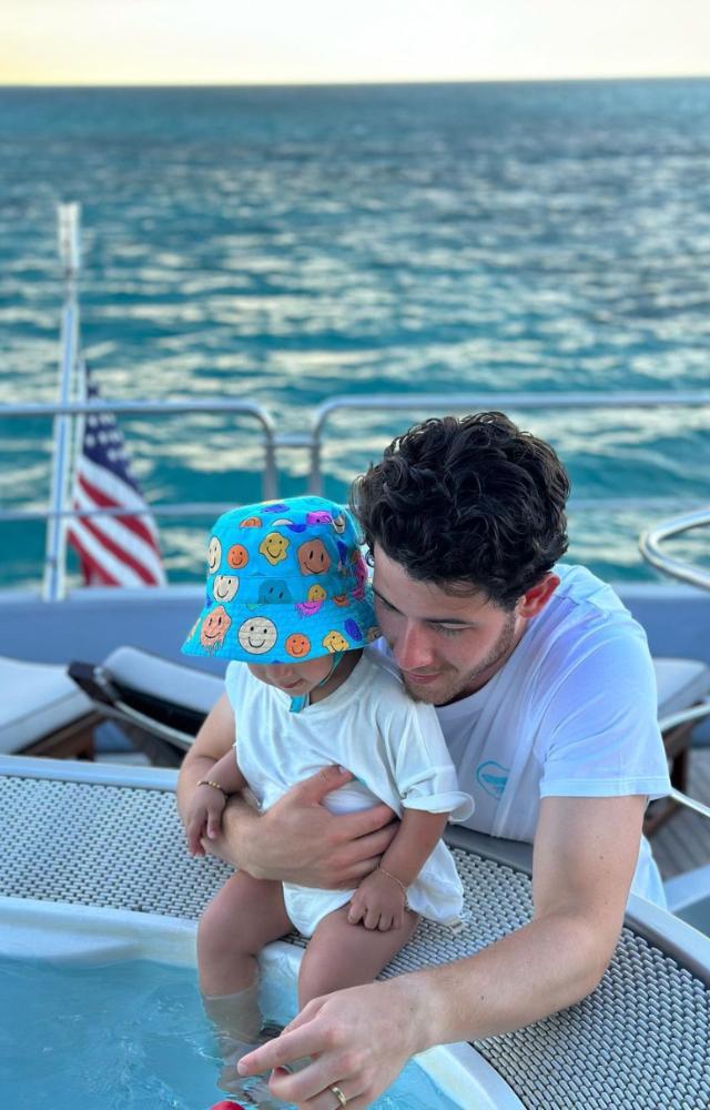 Cuteness overload alert! Daddy Jonas plays with Malti Marie as she dips her feet in the baby pool