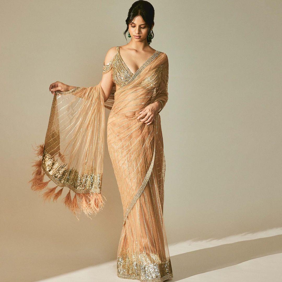 Suhana Khan's wardrobe boasts yet another festive favorite that has caught the attention of fashion enthusiasts. This particular outfit is a soft, earthy-toned sheer saree created by the renowned fashion house Falguni Shane Peacock. 