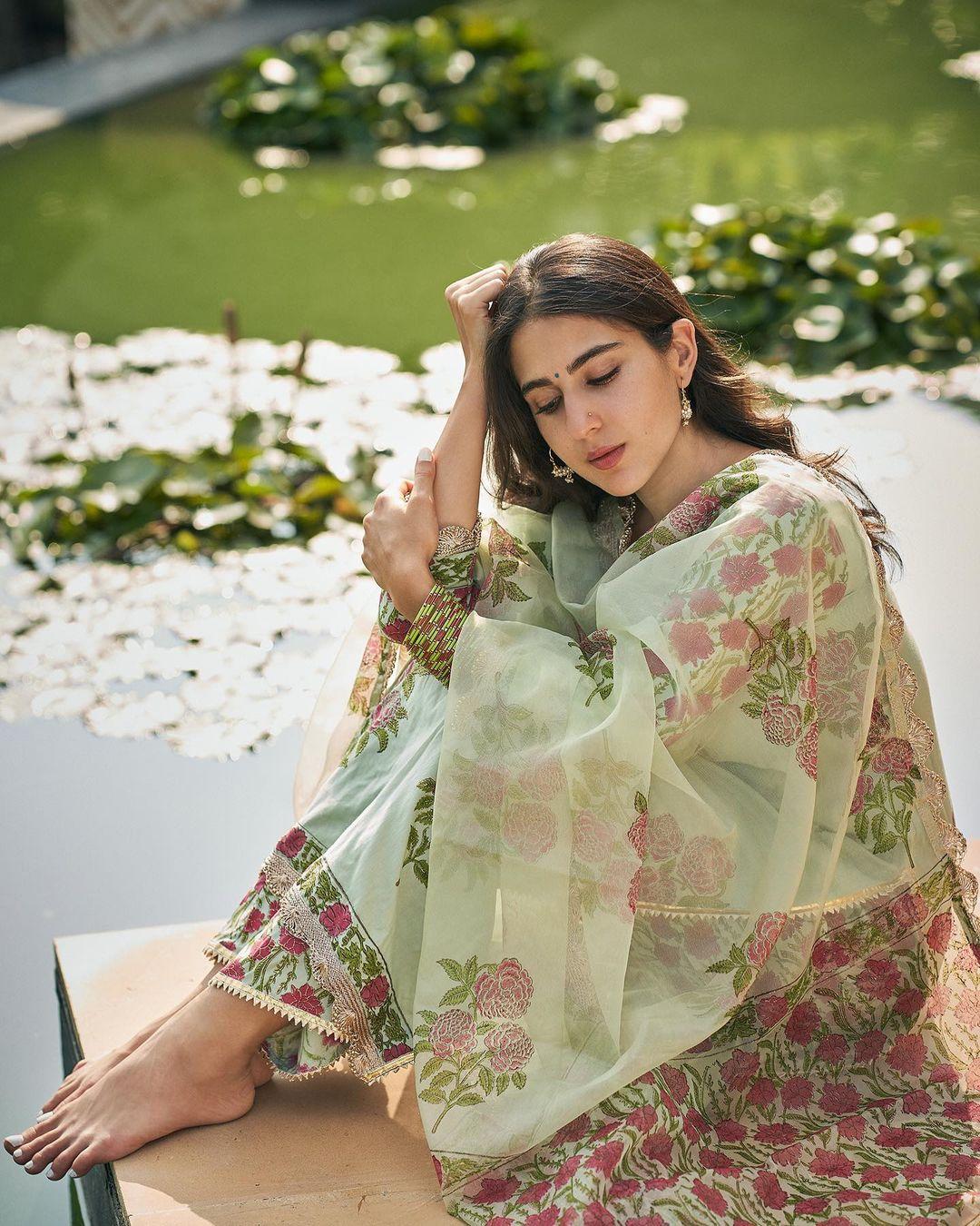  The salwar suit gracefully drapes her figure, enhancing her silhouette and exuding a timeless charm. 