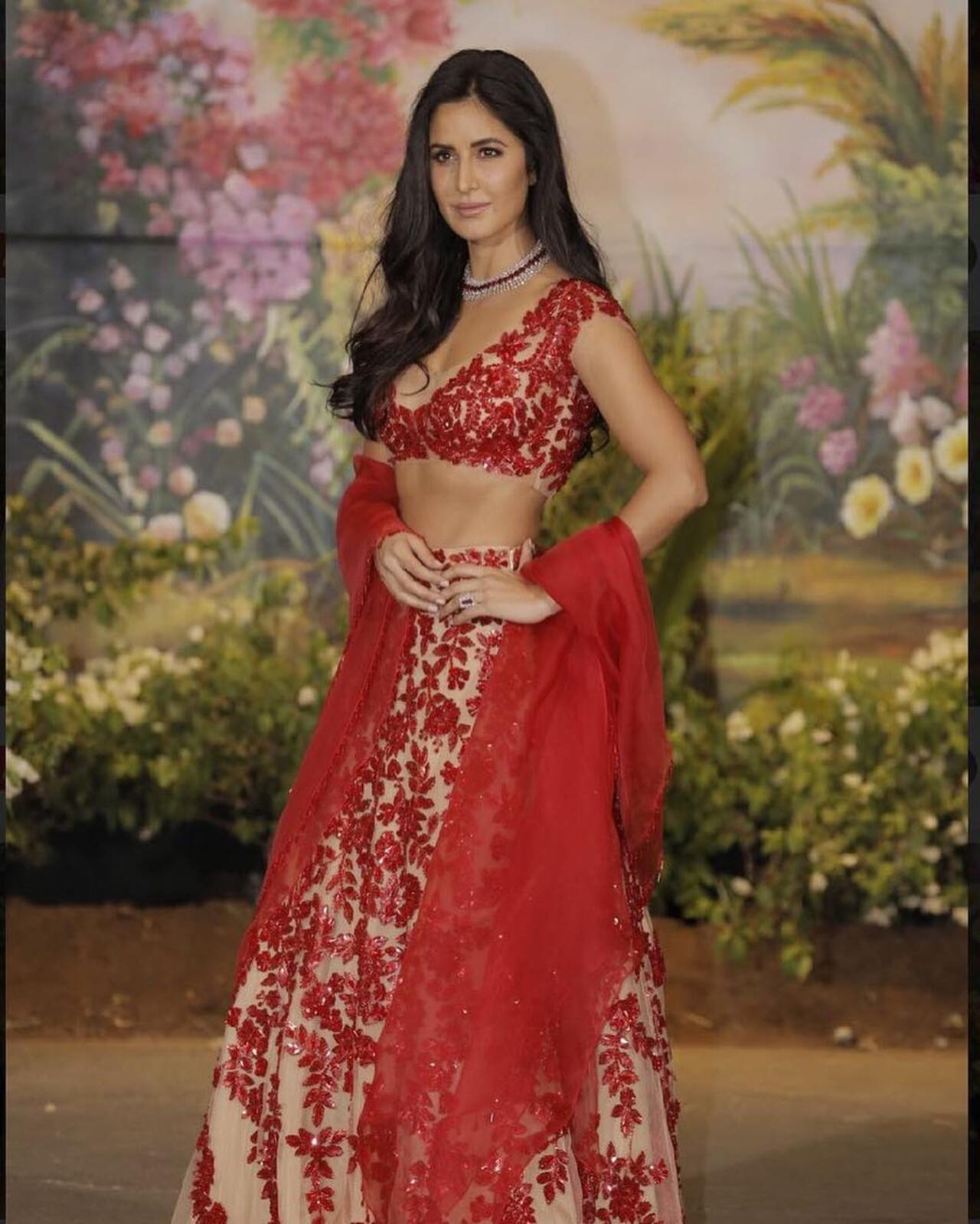 Katrina Kaif
Katrina Kaif is known for her love of fiery hues - and this outfit that she wore to Sonam Kapoor and Anand Ahuja's reception stands out from other red lehengas.  It featured a nude base with ruby-red crystal floral designs. The V-neck blouse gave an illusion of the red motifs as tattoos on her skin, while the skirt showcased red embellishments. She accessorized with a solid red dupatta, presenting a bold nude look with the appearance of the designs floating on a neutral backdrop