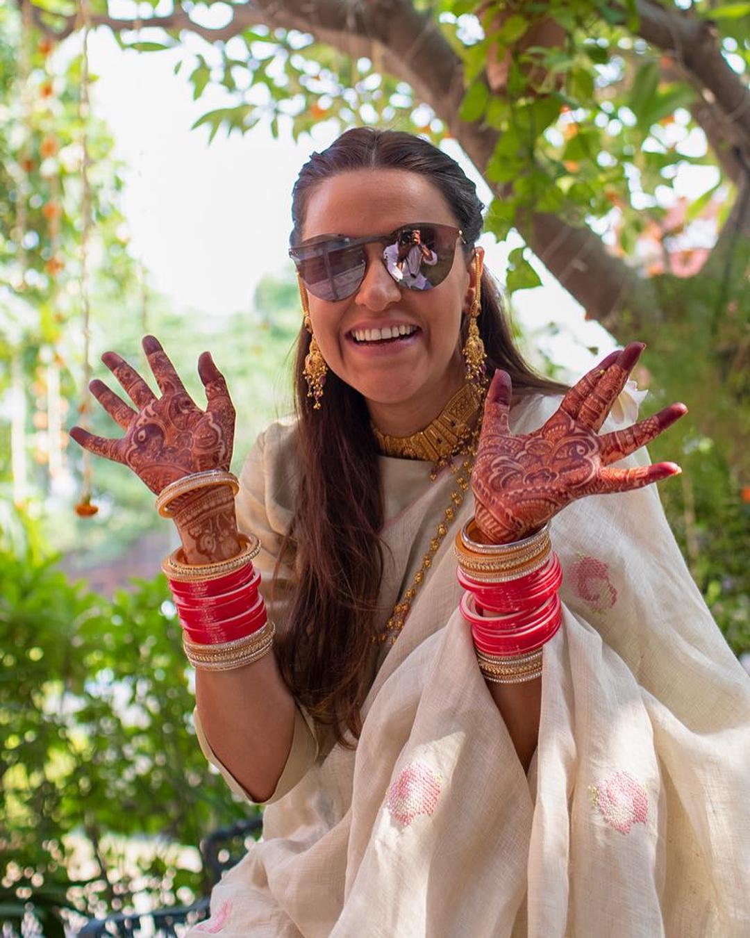 After the intimate mehandi festivities, the couple moved forward with a pre-wedding puja, a ceremonious occasion laden with cultural significance. For this event, Neha Dhupia made a striking choice by donning a delicate beige silk sari designed by Anavila.