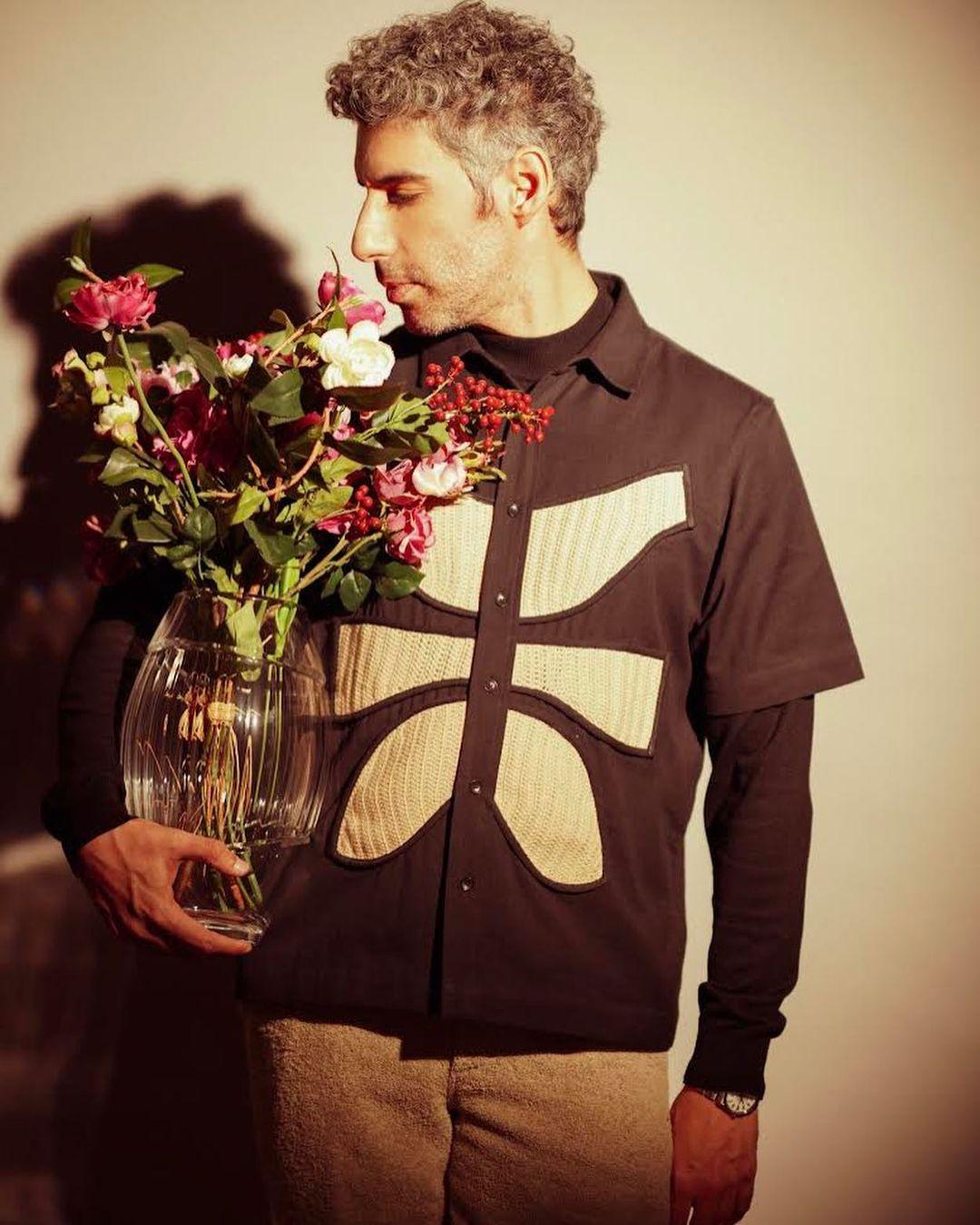 The vest's unique design serves as a focal point, enhancing the overall appeal of his look. 