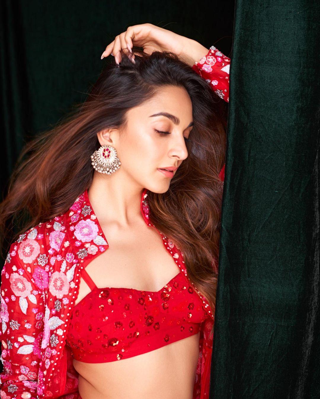Elevating her ethnic charm, she donned a scarlet cape intricately embroidered with floral motifs.