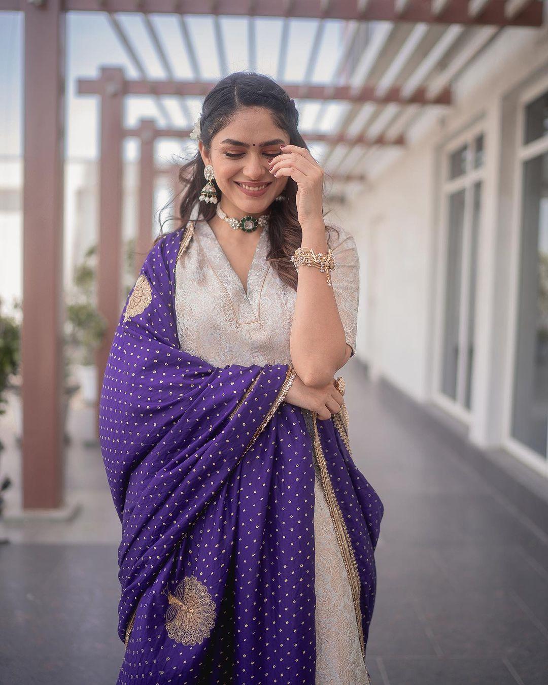  A striking contrast is added by her captivating purple transparent dupatta adorned with intricate designs and golden thread work, breaking the monotony beautifully.