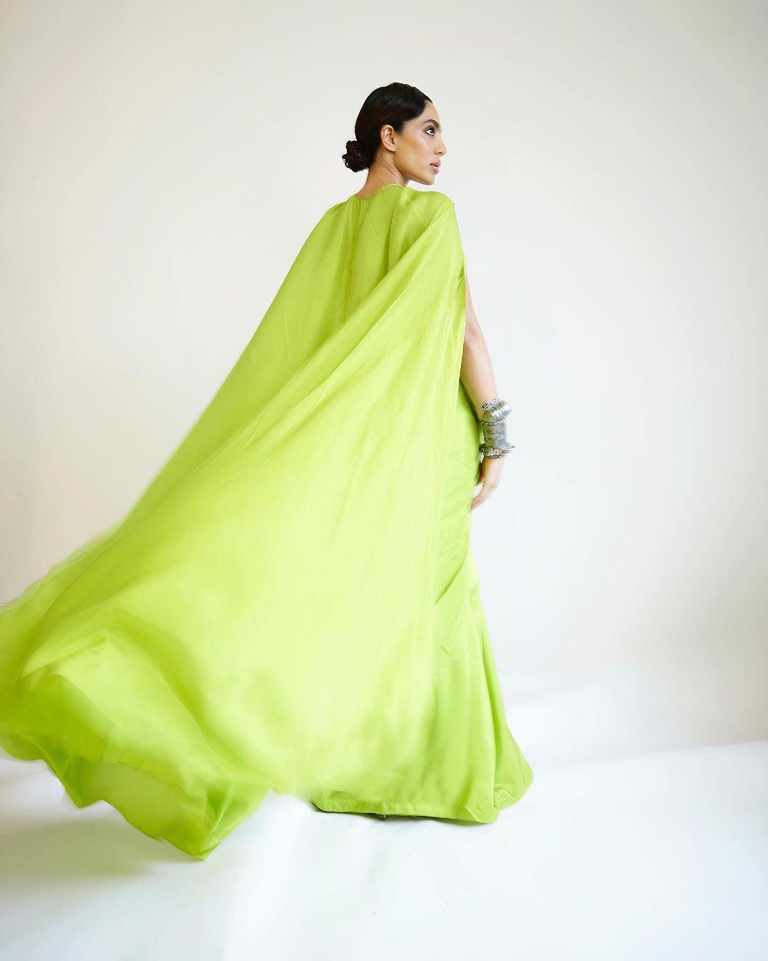 The green cape added a touch of contemporary flair to her traditional attire.