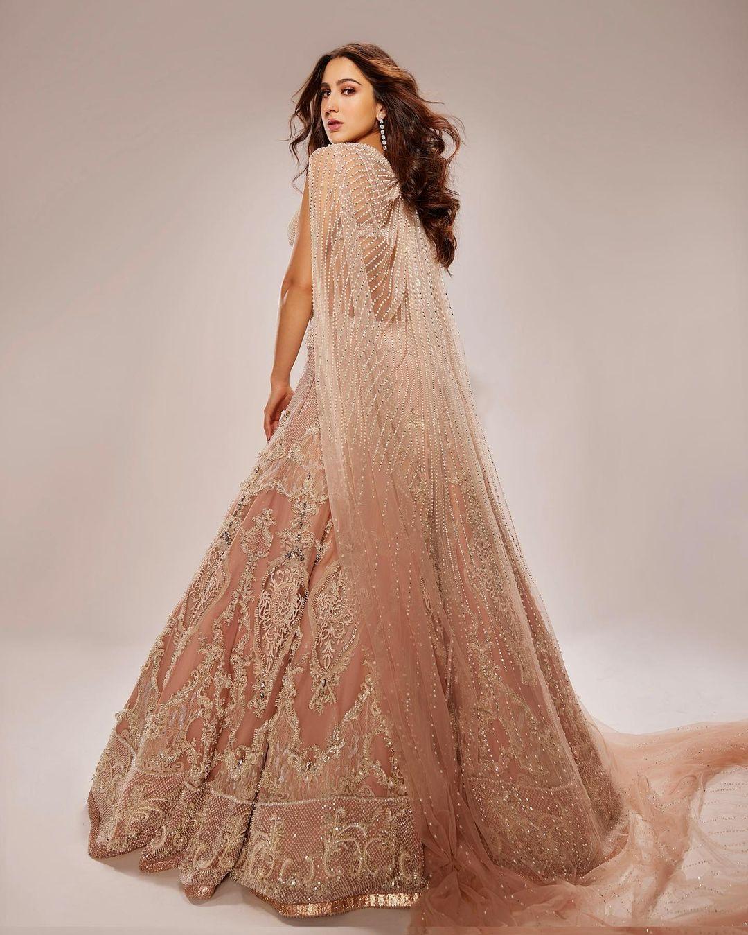 Completing the look is a sheer dupatta, draped elegantly over her shoulders. The dupatta features matching embroidery that mirrors the patterns on the lehenga, creating a harmonious visual symphony. The delicate fabric falls gracefully, adding movement and fluidity to the ensemble.