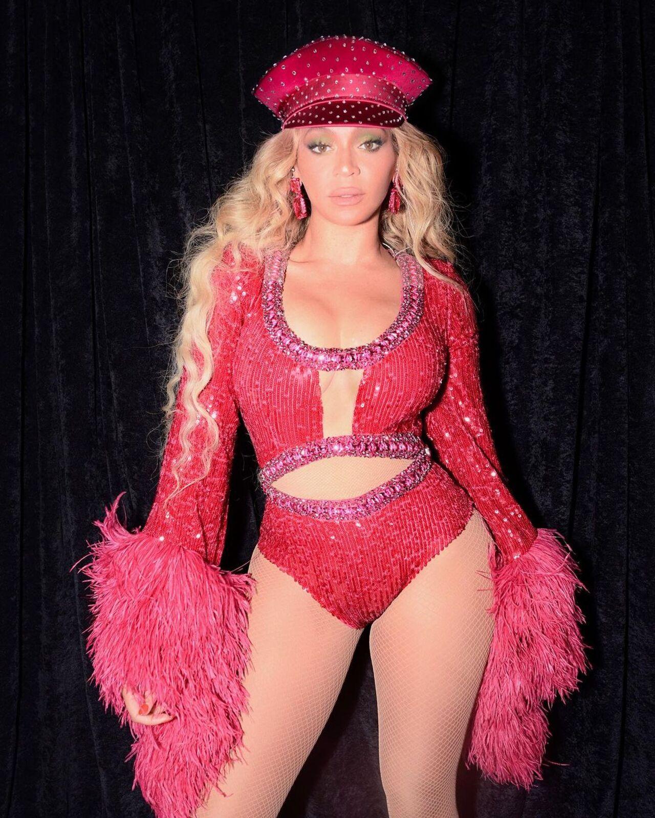 Beyonce exuded sheer power and charisma in her glamorous pink bodysuit with furry confetti-style sleeve ends. With that sensual sailor cap, she is ready to rock!