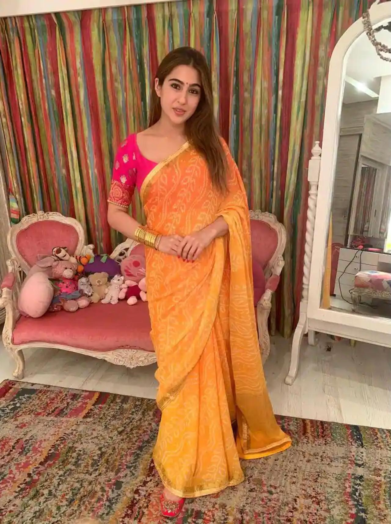 Sara Ali Khan
Fashionista Sara chose a vivid orange and yellow saree with an ombre bandhani effect and complemented it with a striking hot pink blouse featuring half sleeves. Add some gold bangles like Sara to elevate your ethnic attire