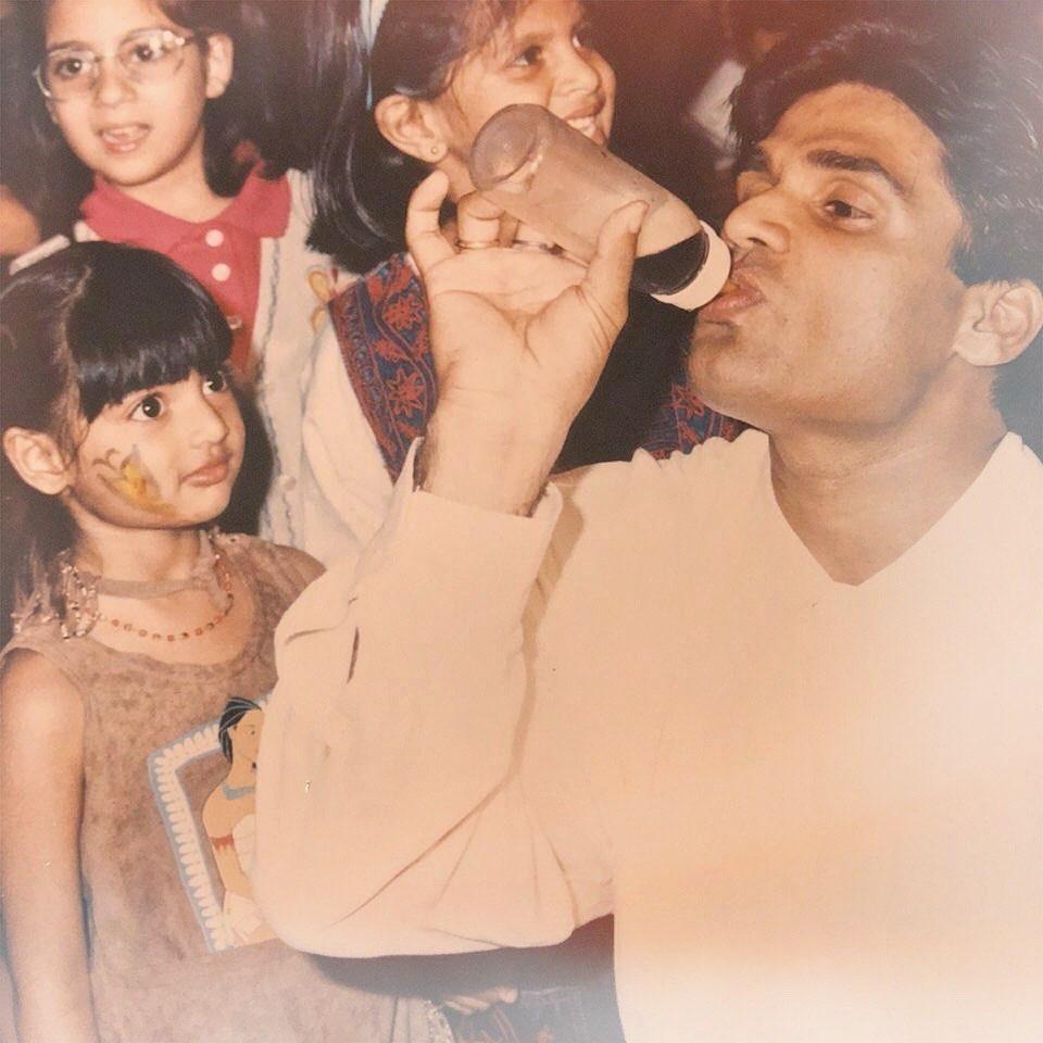 Athiya's watchful gaze as her dad takes a sip from a bottle captures a tender moment of shared connection.