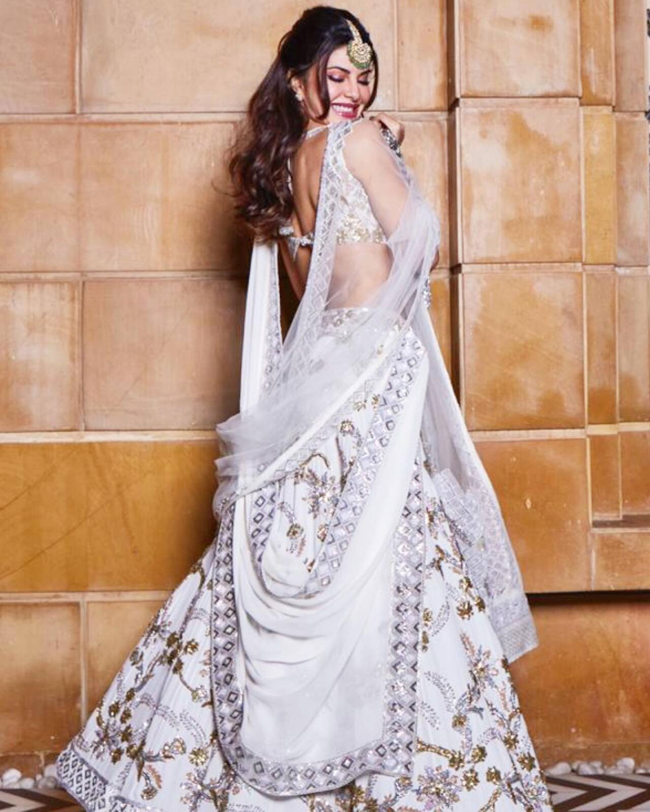 Jacqueline Fernandez
At Isha Ambani and Anand Piramal's Udaipur pre-wedding festivity, luminaries from Bollywood, global fame, fashion, and politics donned their designer finest. Among them, Jacqueline Fernandez was particularly striking in an ivory Manish Malhotra lehenga with subtle gold detailing. Styled by Chandi Wabhi, she complemented her attire with bangles, earrings, and a maang tikka