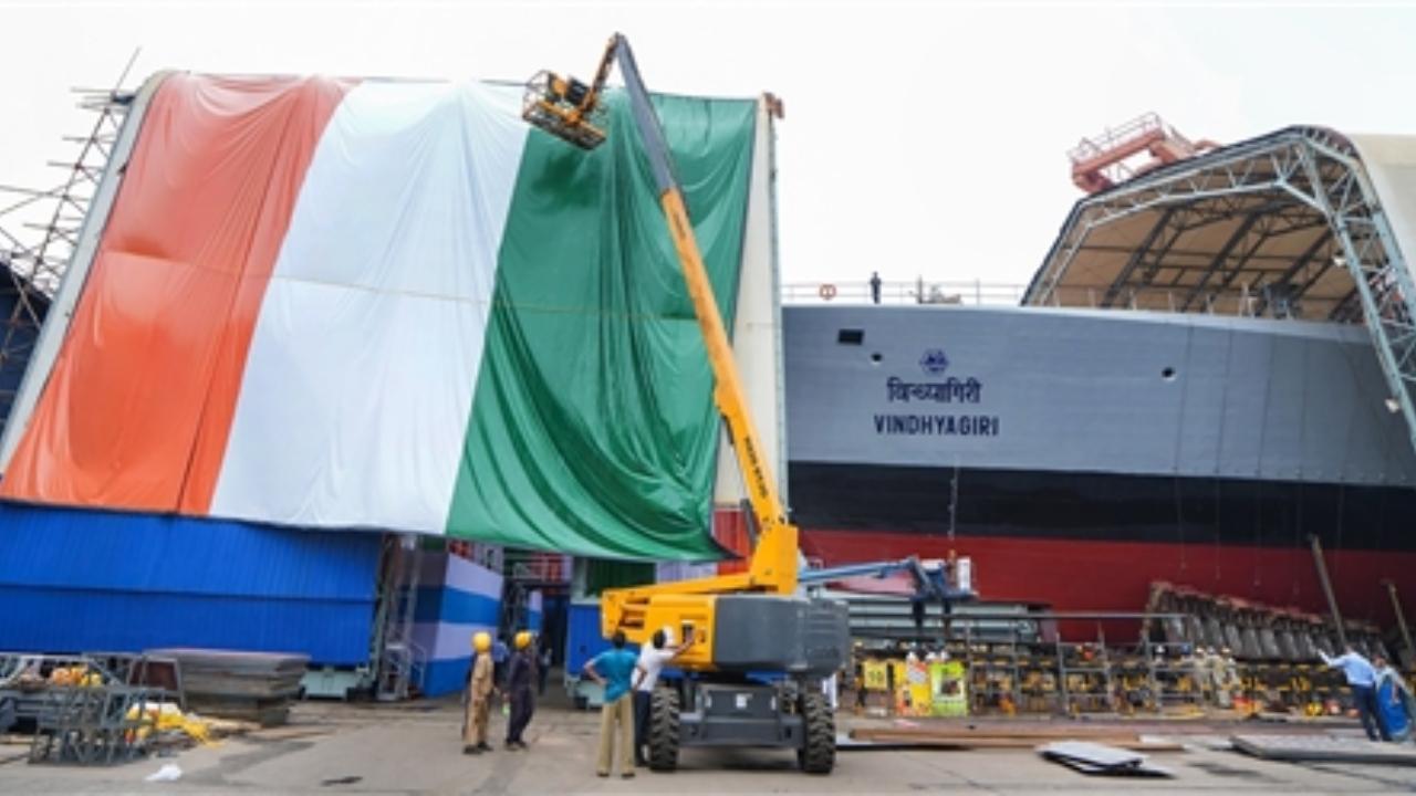Huge cranes were at work delivering material to the deck of the ship, while some items were being unloaded from it, with senior engineers supervising the final construction activities in the warship in-making