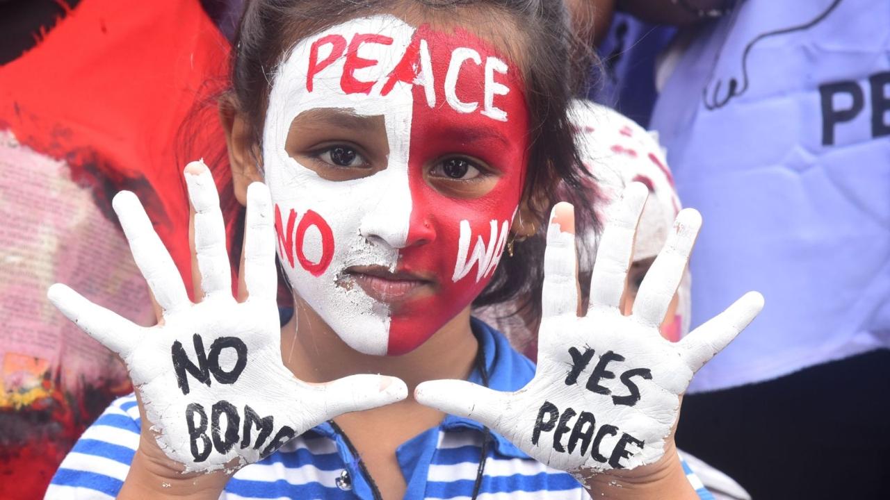 NSS volunteers from college standing with peace message painted on their face and hands