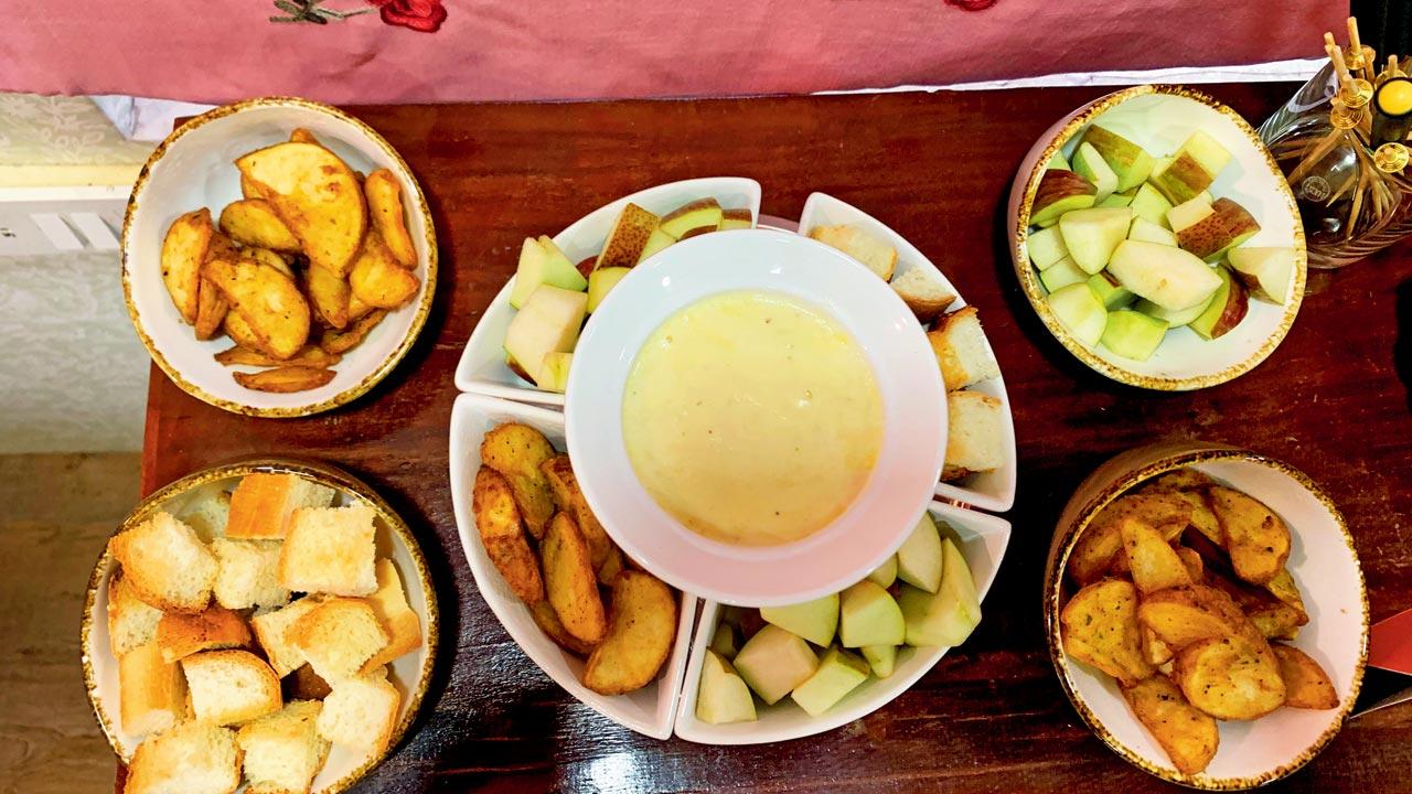 Croutons and apple wedges around a gruyère cheese fondue