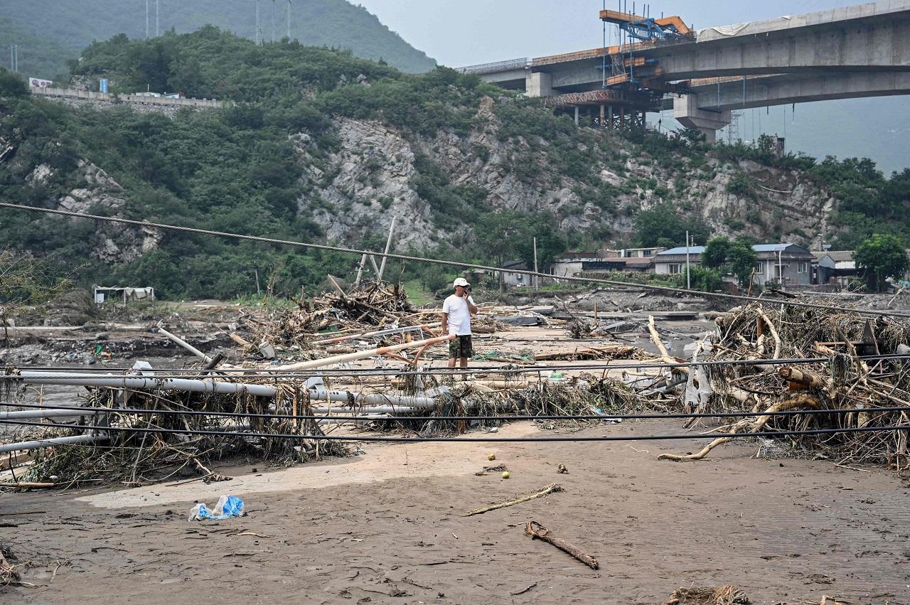 Beijing and the surrounding province of Hebei were hit by severe flooding because of the record rainfall, with waters rising to dangerous levels. The rain destroyed roads and knocked out power and even pipes carrying drinking water. It flooded rivers surrounding the capital, leaving cars waterlogged, while lifting others onto bridges meant for pedestrians