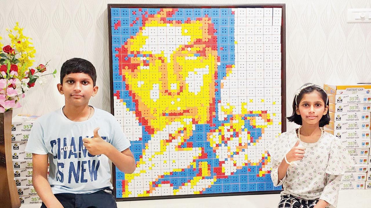 Ethan and Annie Singh pose with their mosaic of Ernö Rubik made of Rubik’s cubes
