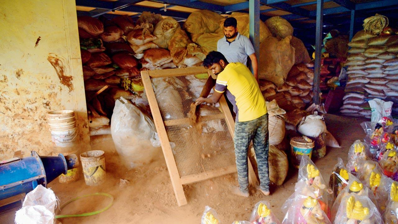 A worker at Vruksha Gajanan’s karkhana seen sieving farm soil, after stones and other dry waste are extracted from it. The soil is sieved at least thrice, before it is pulverised to create a fine, powder form. The soft soil that is procured is then mixed with water, and left for maturation. This can take at least 20 to 25 days, because each and every particle of the soil needs to be drenched completely. The mitti that is procured by the end of this laborious process has the texture of clay, and can be moulded into any form. Pics/Pradeep Dhivar