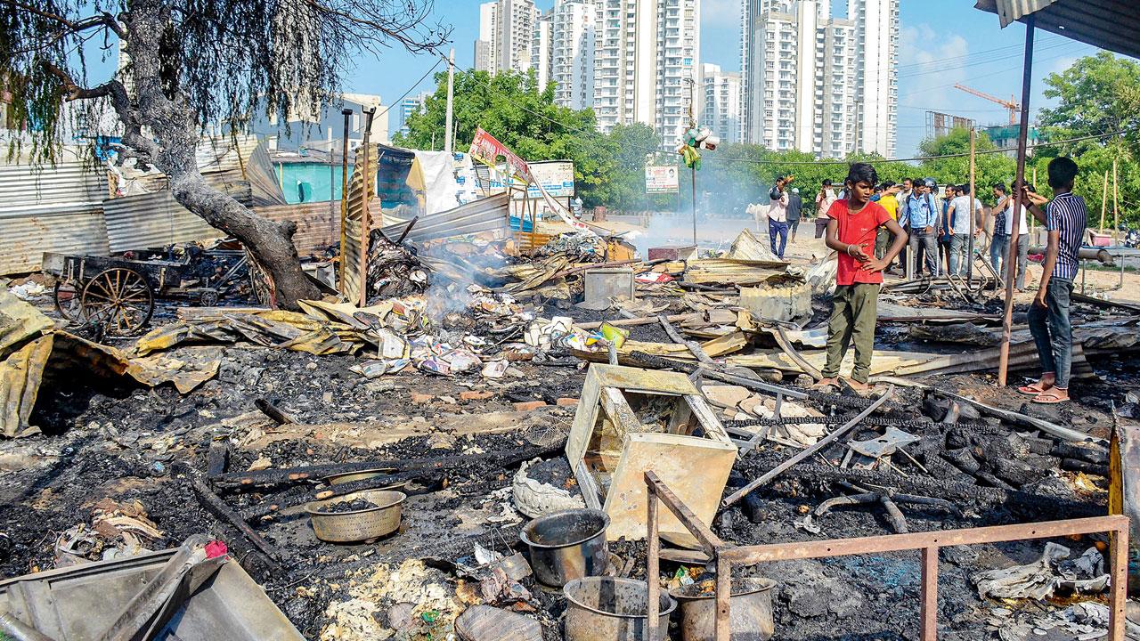 A worker inspects burnt items at a shop that was set ablaze by miscreants, at Sector 67 in Gurugram, Haryana, on Tuesday. Pic/PTI