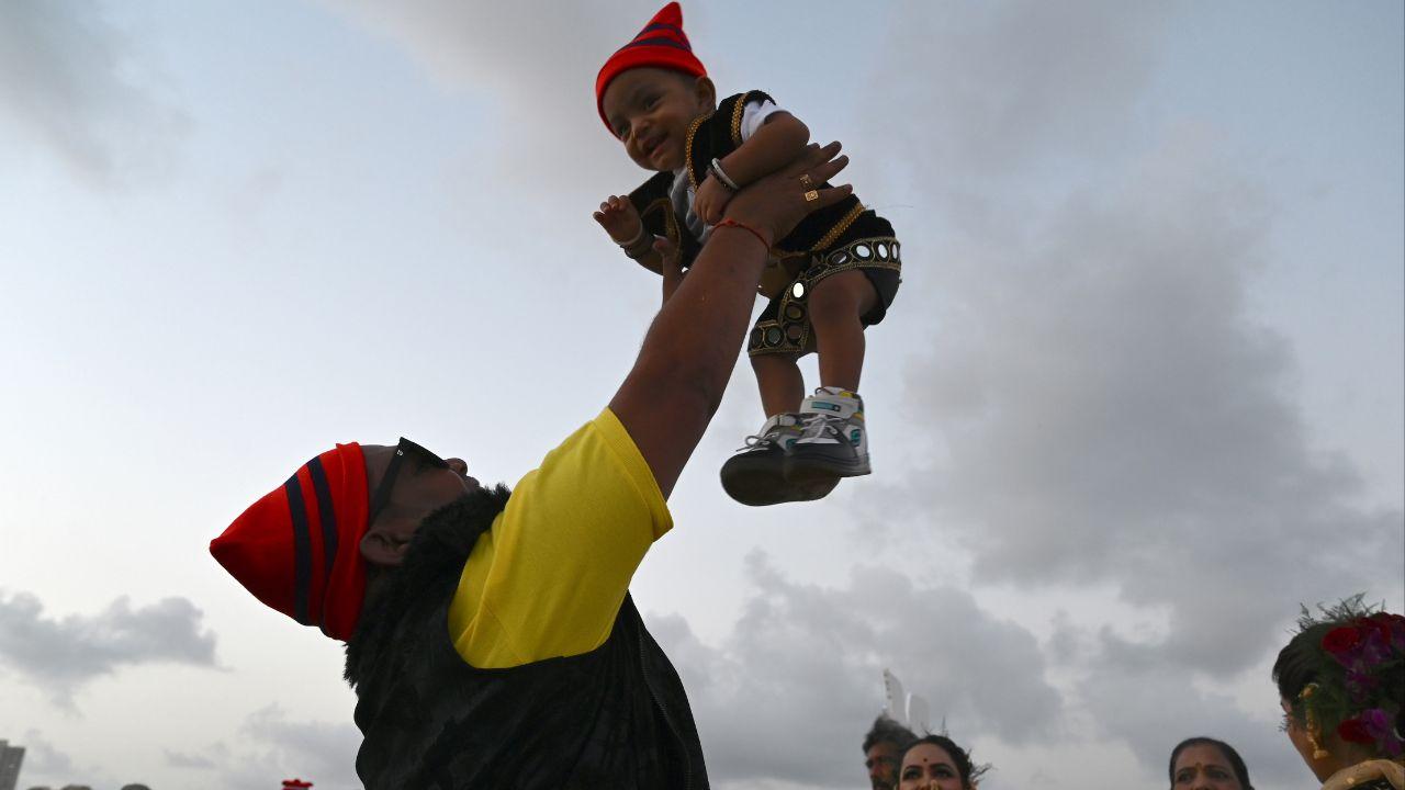 A member from the Koli community, amid the festivities of Narali Pournima, was seen playing with a child. Pic/AFP