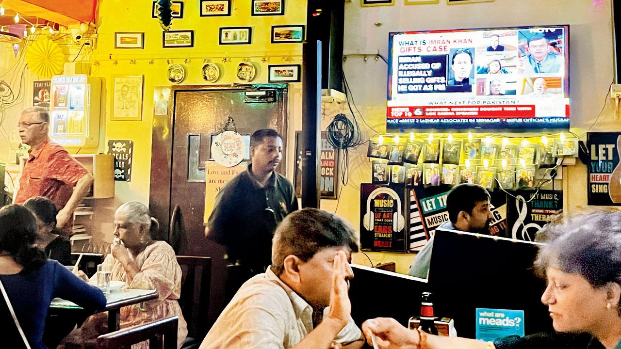 News plays on the television as patrons converse at the Bandra restaurant