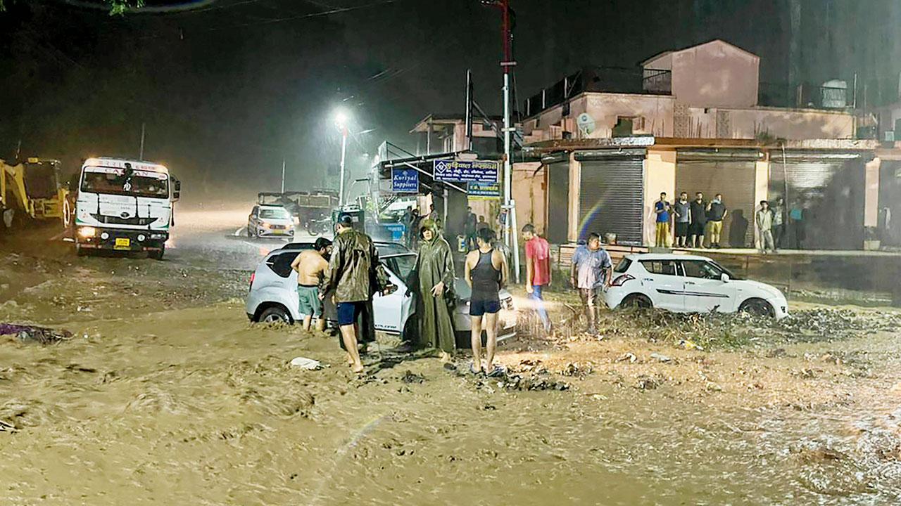 Vehicles stuck in a manhole amid heavy rain, in Rishikesh, Uttarakhand on Tuesday