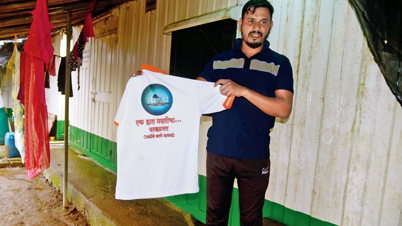 Sunil Shiravale holding the t-shirt which he gifted to Irshalwadi landlside survivors