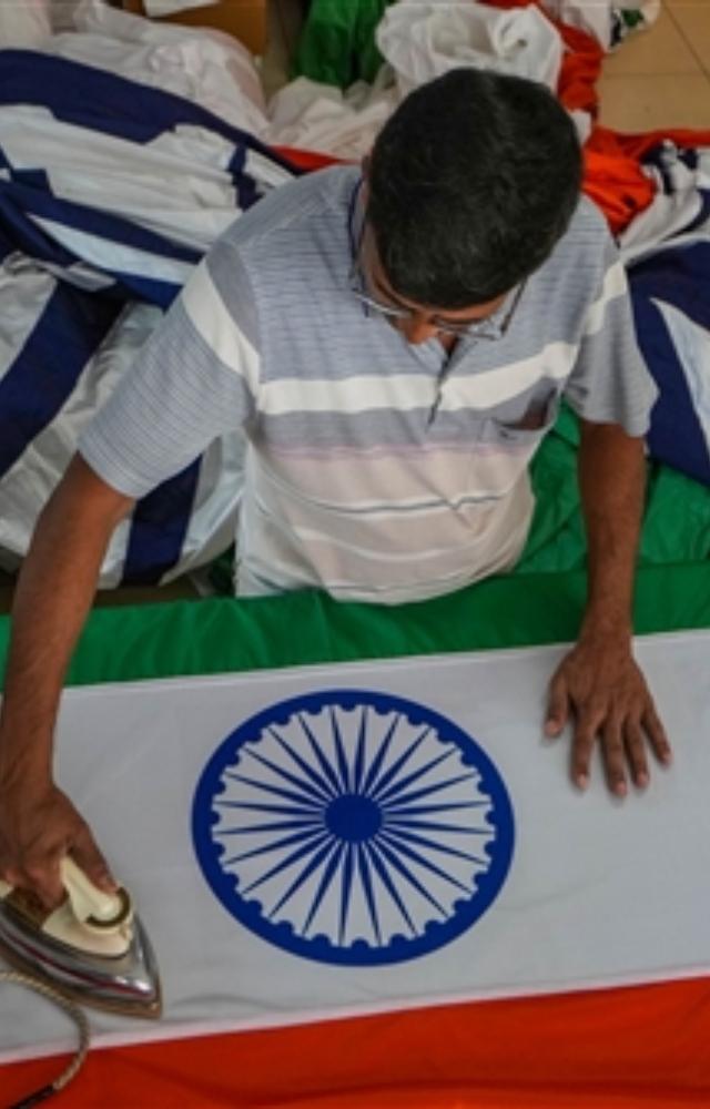 A worker irons an Indian national flag ahead of I-Day celebrations