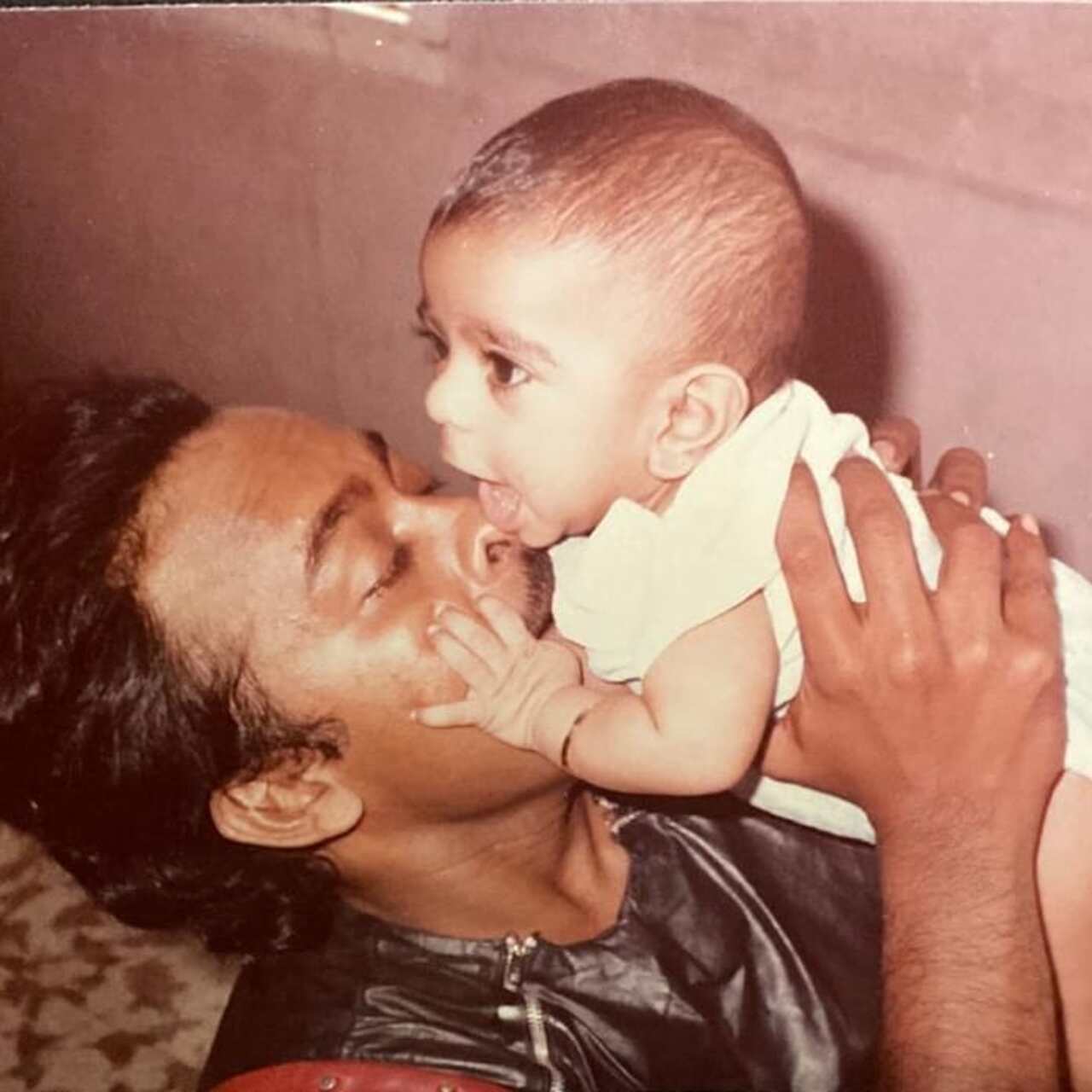 Chiranjeevi holds and plants a kiss on toddler Ram Charan. The actor is seen in a film costume as the picture was probably clicked on a film set