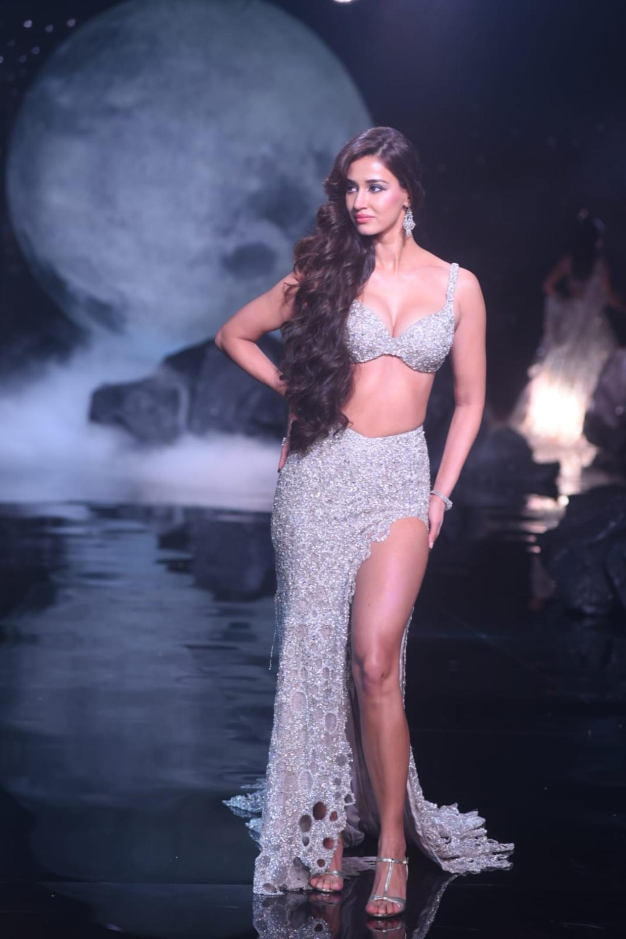 Disha Patani turned showstopped for the 'Selene' collection at India Couture Week. Her sequinned silver bralette and asymmetrical skirt evoked much of the gentle radiance of the moon. The pearly white sequins, metallic tissues, ivory tulle, and iridescent silver sequins embedded in the outfit mirrored the moon's ethereal glow (Pic/Pallav Paliwal)