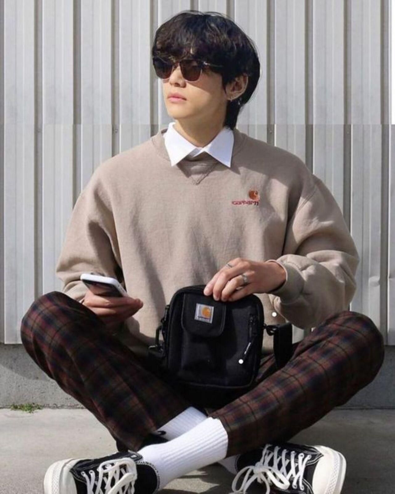Taehyung's wardrobe is much like Namjoon's in that it is filled with muted and earthy colours. He also loves his plaid - and looks like the artist he is is this layered sweater-shirt