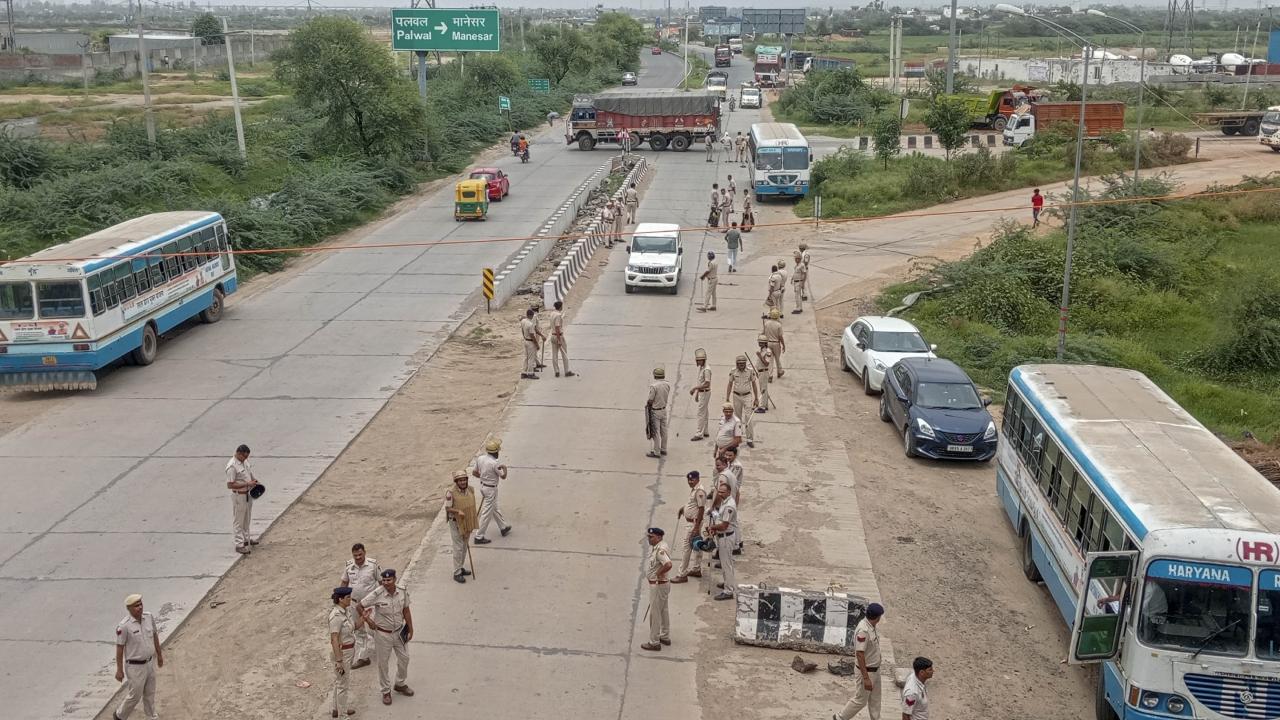 Security personnel stand guard after Haryana Roadways resumed services from the violence-hit Nuh district. Pics/PTI