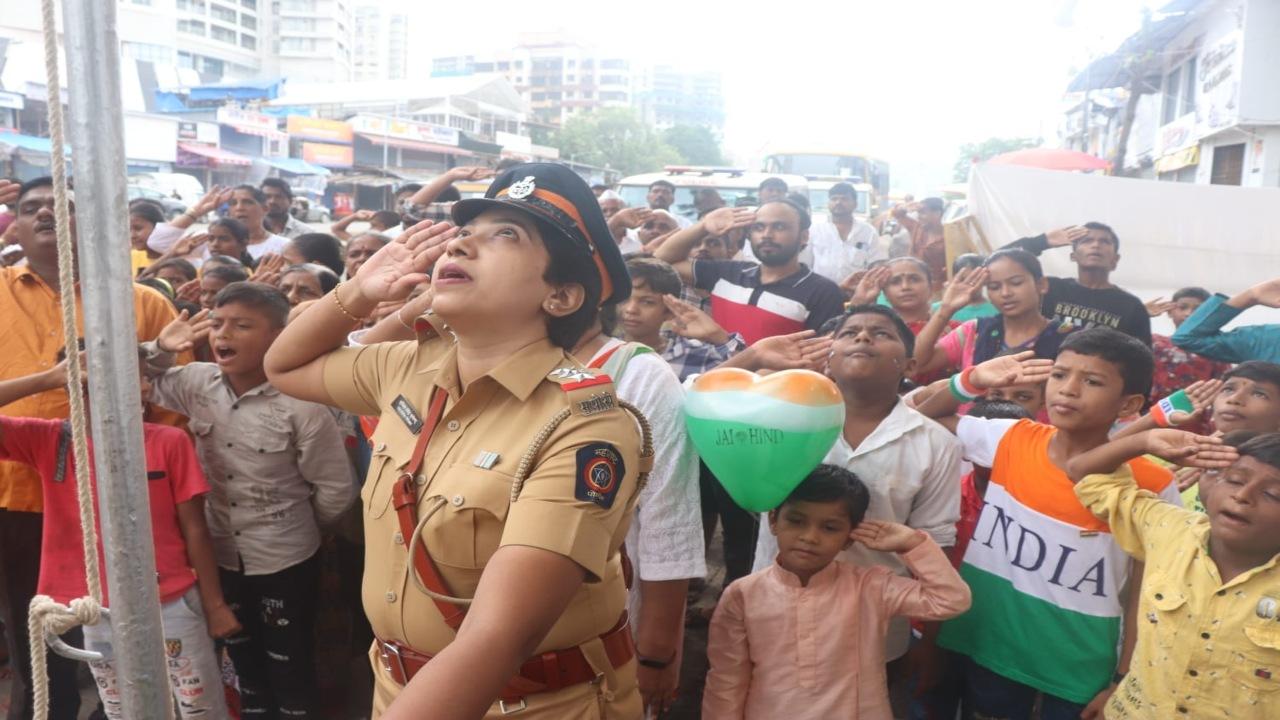 A female police officer seen saluting the Indian national flag, tricolour, on the occasion of the country's 77th Independence day in Mumbai. Photo/Anurag Ahire