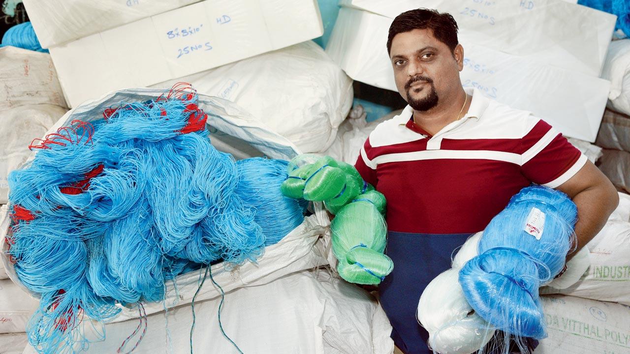 Kiran Tare, who works at the Satpati Fishermen Sarvoday Sahakari Society Ltd, shows the net (in blue, left)  used for gillnet fishing