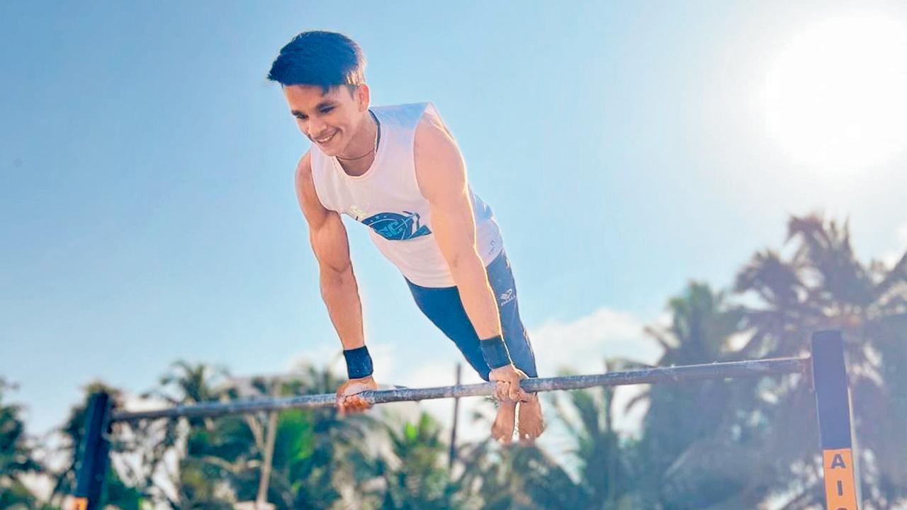 A participant performs a bar planche  at an earlier competition