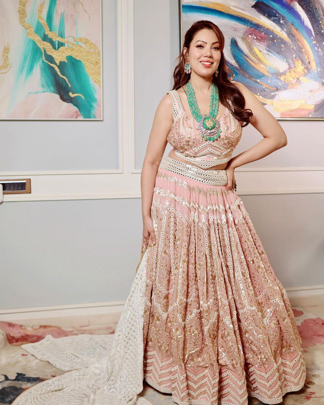 In this look, Munmun wore a stunning peach-coloured lehenga and added a touch of playfulness by adding contrasting green jewellery