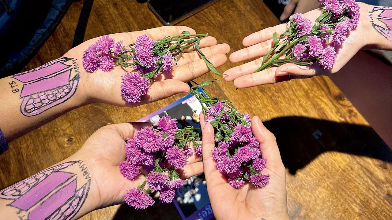 Fans paint the band’s logo on their hands