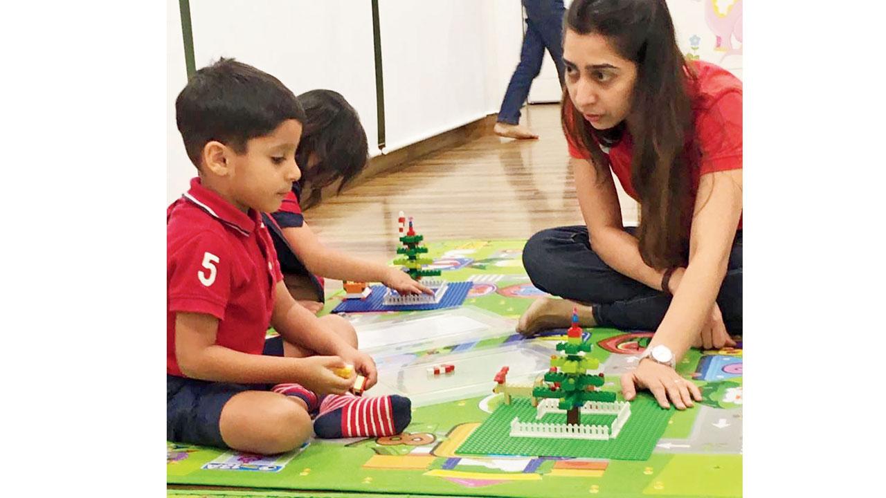 Dhara Mehta (right) shows kids how to build a Chritmas tree